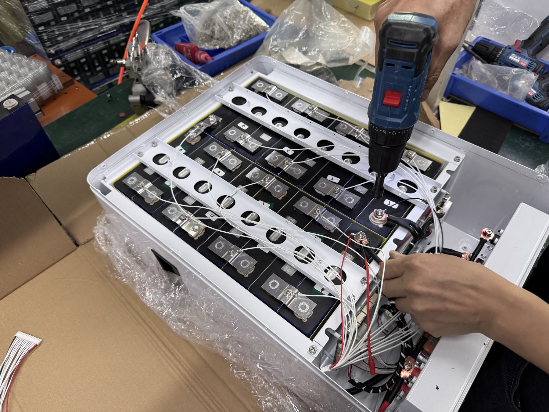 Battery pack wiring and terminals visible during production assembly