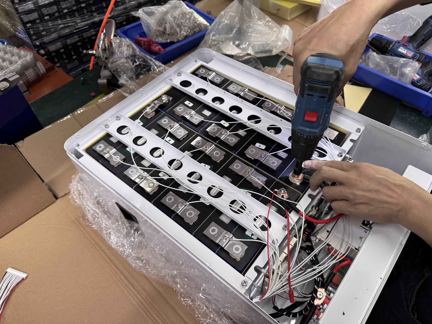 Technician working on a battery assembly at a manufacturing facility